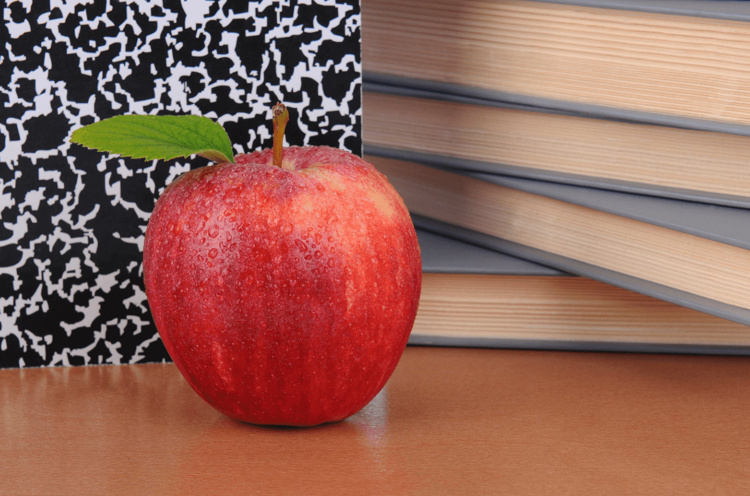 Apple next to books on a teacher's desk